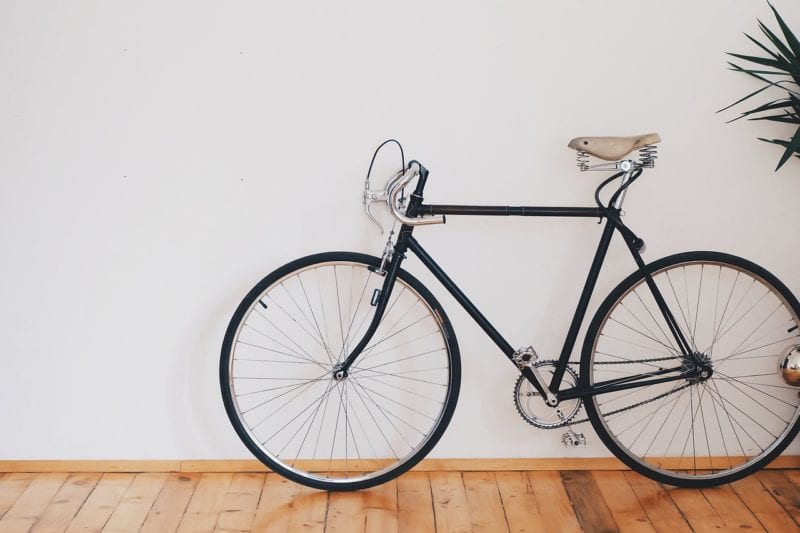 schwarzes Fahrrad auf Holzboden