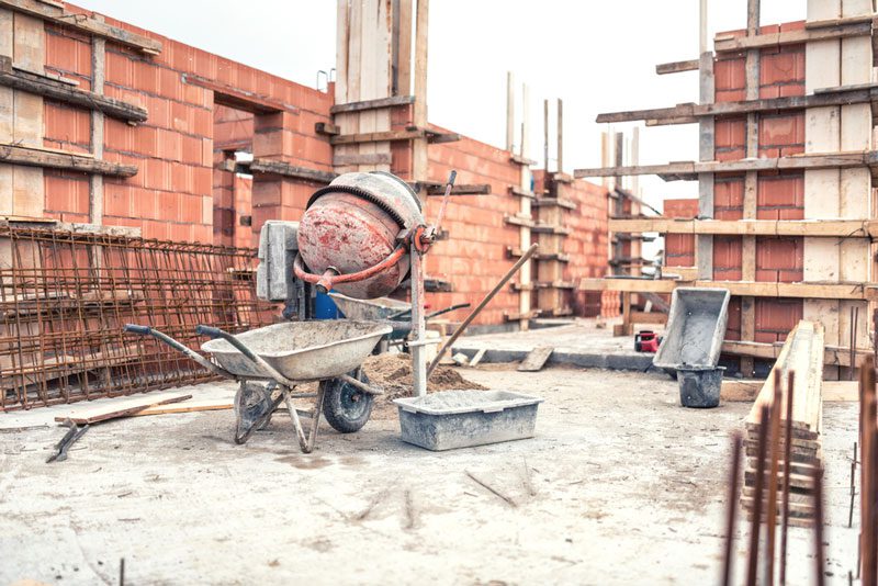 Baustelle mit Schubkarre und Zementmischer