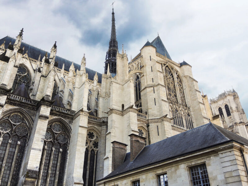 Außenansicht der gotischen Kathedrale von Amiens mit Strebepfeilern, Strebebögen, hohen Maßwerkfenstern und Vierungsturm.